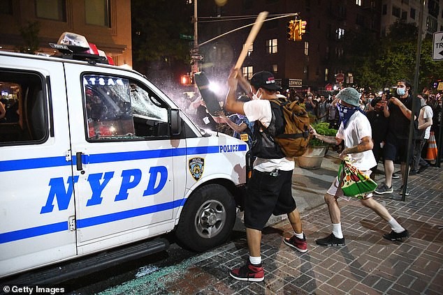 Người biểu tình đập phá xe cảnh sát New York. Ảnh: Getty