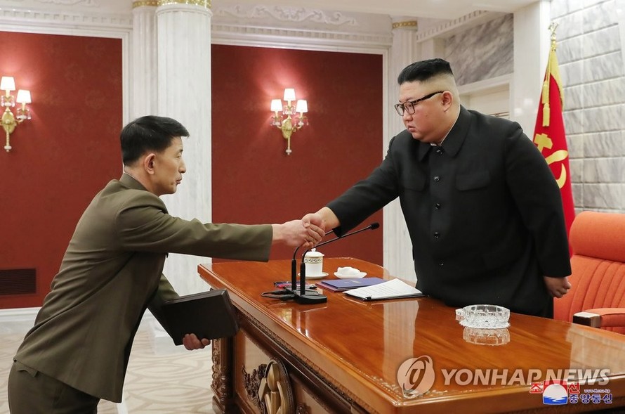 Ông Kim Jong-un trao quyết định bổ nhiệm cho các tướng lĩnh quân đội mới. Ảnh: Yonhap