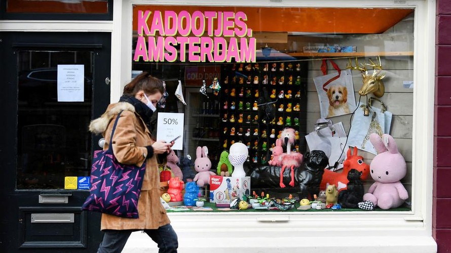 Một người phụ nữ đeo khẩu trang đi bộ ở Amsterdam (Hà Lan). Ảnh: Reuters