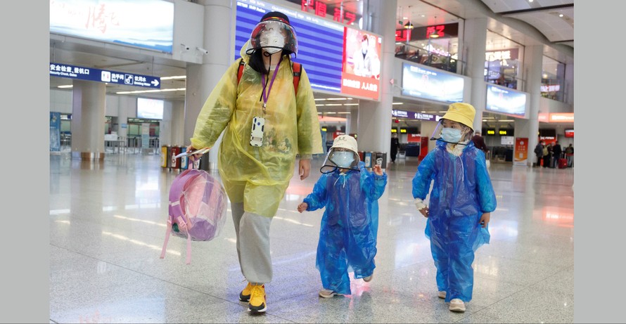 Hành khách bảo hộ kín mít ở sân bay quốc tế Bắc Kinh vắng lặng. Ảnh: Getty.