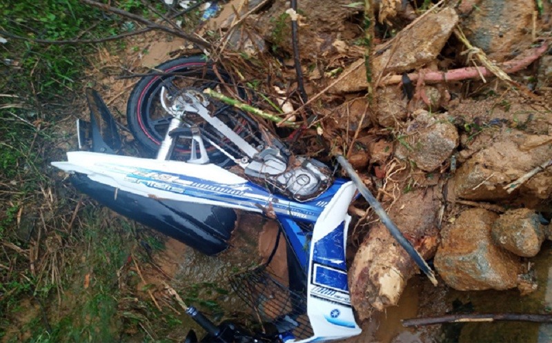 Chiếc xe máy của 2 thanh niên người Quảng Nam bị đất đá vùi lấp. Ảnh: CTV