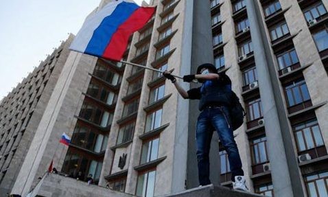 Một người biểu tình cầm cờ Nga tại trụ sở chính quyền ở Donetsk. Ảnh: Getty.