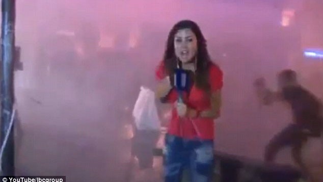Nữ phóng viên áo đỏ đang đưa tin giữa cuộc bạo loạn ở Beirut thì bị người biểu tình tấn công