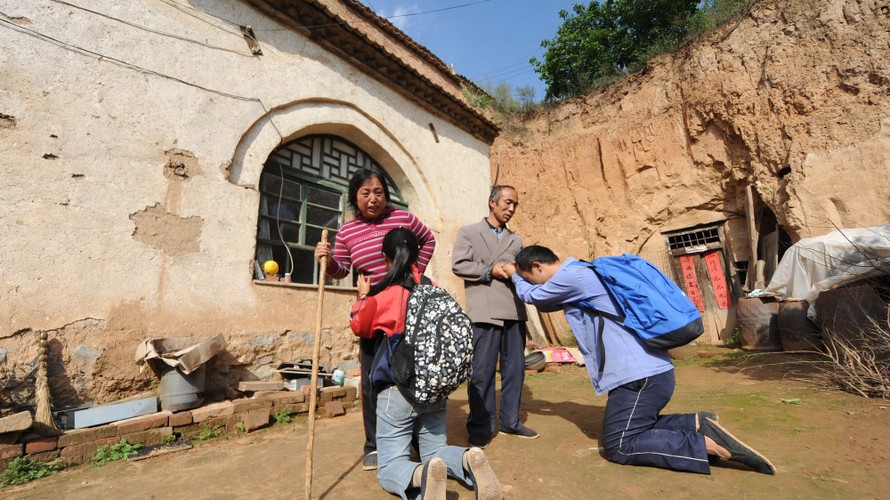 Hai anh em quỳ lạy cha mẹ nghèo trước khi lên đường đi học xa nhà