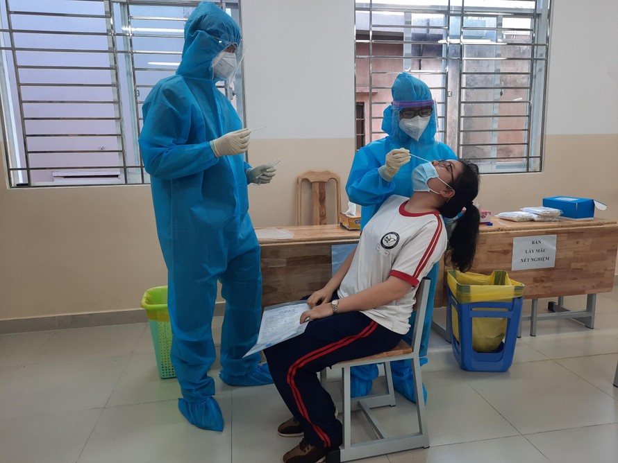 Nhân viên y tế lấy mẫu xét nghiệm COVID-19 cho thí sinh sáng ngày 3/7 (ảnh: Chang Chang)