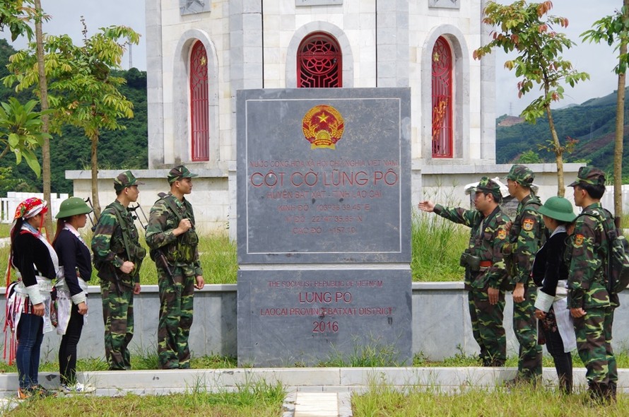 Đội tuần tra Đồn biên phòng A Mú Sung giới thiệu cột cờ Lũng Pô cho dân quân tham gia tuần tra với BĐBP