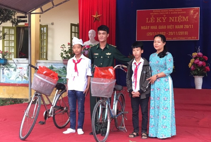 Chỉ huy Tiểu đoàn Huấn luyện - Cơ động Bộ đội Biên phòng Lào Cai tặng xe đạp cho hai em Thắng và Vảng