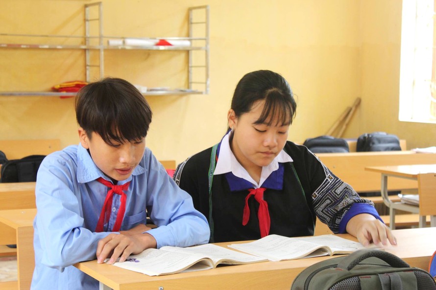 Em Sùng Thanh Tâm (bên phải) ngồi học bài dưới ánh sáng mới của lớp học