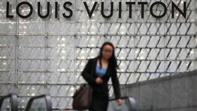 Một phụ nữ đi qua một cửa hiệu Louis Vuitton ở Thượng Hải, Trung Quốc. Ảnh: Reuters/BI.