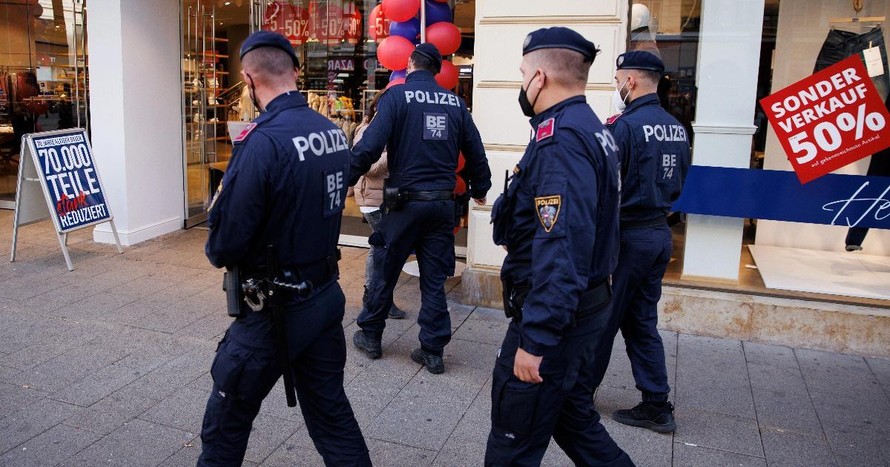 Cảnh sát tuần tra kiểm tra giấy chứng nhận tiêm chủng của người đi mua sắm trên đường phố Vienna, Áo (Ảnh: Reuters).
