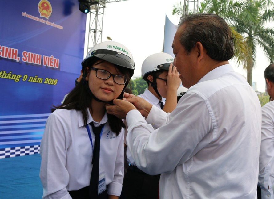 Phó Thủ tướng Trương Hoà Bình đội mũ bảo hiểm cho học sinh ngày khai giảng