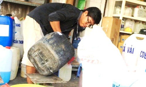 Nam thanh niên trong cửa hàng ở chợ Kim Biên đang chiết axit cho khách. Ảnh: Hải Hiếu/VnExpress