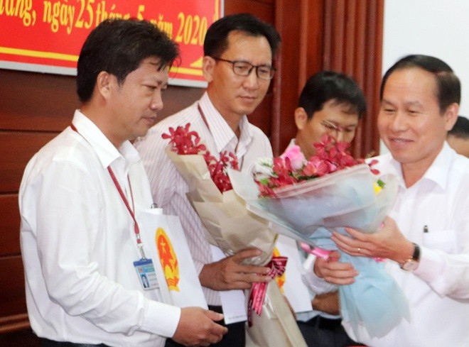 Chủ tịch UBND tỉnh Hậu Giang Lê Tiến Châu tặng hoa chúc mừng ông Phan Vĩnh Lộc (bìa trái). Ảnh: Nhật Tân/Zing.