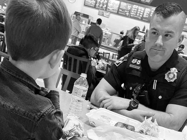 Hành động đáng yêu của một cậu bé khi nhìn thấy chú cảnh sát ngồi ăn một mình